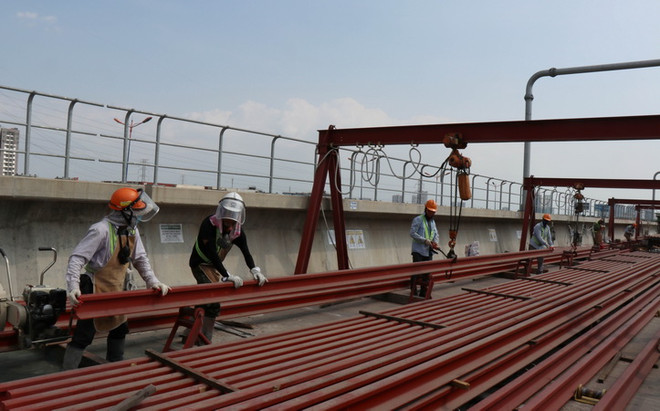Công nhân thi công đường ray tuyến metro số 1 tại ga Phước Long. (Ảnh: Tiến Lực/TTXVN) Dự án metro số 1 TP.HCM giảm 3.400 tỷ đồng tổng mức đầu tư ảnh 1