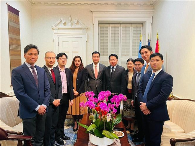 Đại sứ Đặng Hoàng Giang (thứ 5 từ trái qua) chúc mừng Tết cổ truyền Bunpimay với Đại sứ Anouparb Vongnorkeo (thứ 5 từ phải qua). (Ảnh: TTXVN phát) Việt Nam chung vui Tết cổ truyền cùng Lào và Campuchia ảnh 1