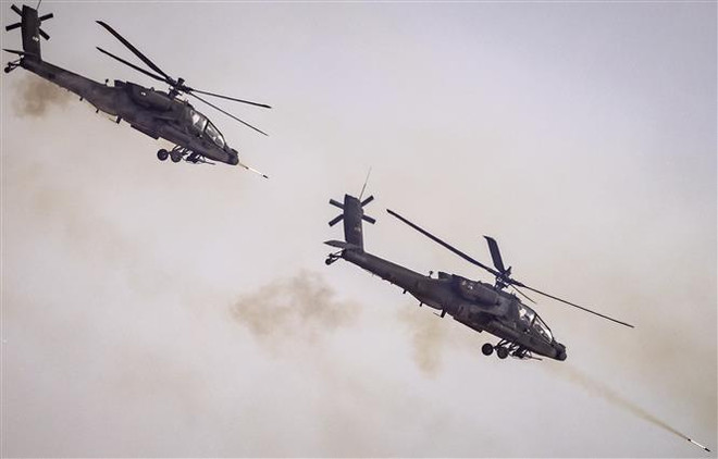 Máy bay AH-64 Apache của quân đội Mỹ tham gia tập trận ngày 30/6/2022. (Ảnh: AFP/TTXVN) Rơi trực thăng sau huấn luyện tại Mỹ: 3 trong 4 phi công tử nạn ảnh 1