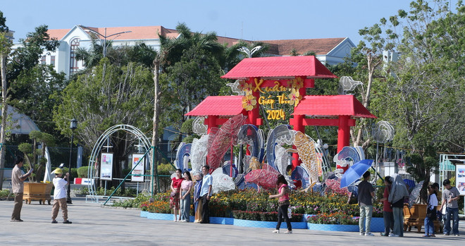 Khách du lịch tham quan, chụp ảnh tại các tiểu cảnh điểm du lịch Quảng trường Hùng Vương, thành phố Bạc Liêu. (Ảnh: Tuấn Kiệt/TTXVN) ttxvn_1302_bac lieu du lich (2).jpg