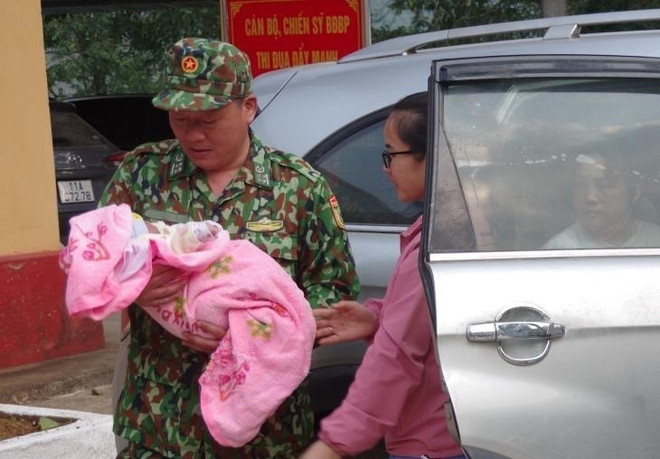 Đại diện Bộ đội Biên phòng Cao Bằng bàn giao cháu bé sơ sinh trong chuyên án mua bán người dưới 16 tuổi cho cơ quan bảo trợ xã hội địa phương. (Ảnh: Nông Tuấn/TTXVN phát) ttxvn_3011_mua ban nguoi2.jpg