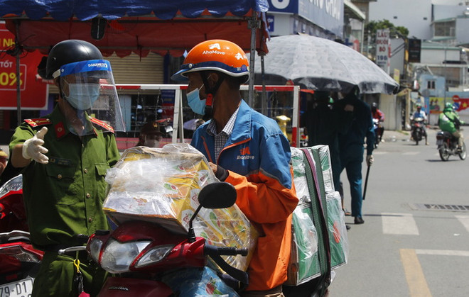 Lực lượng Công an và dân quân phường 11, quận Bình Thạnh trực kiểm soát tại chốt ngã tư đường Lê Quang Định-Phan Văn Đậu. (Ảnh: Thanh Vũ/TTXVN) Dịch COVID-19: TP Hồ Chí Minh siết chặt quản lý dịch vụ shipper ảnh 1