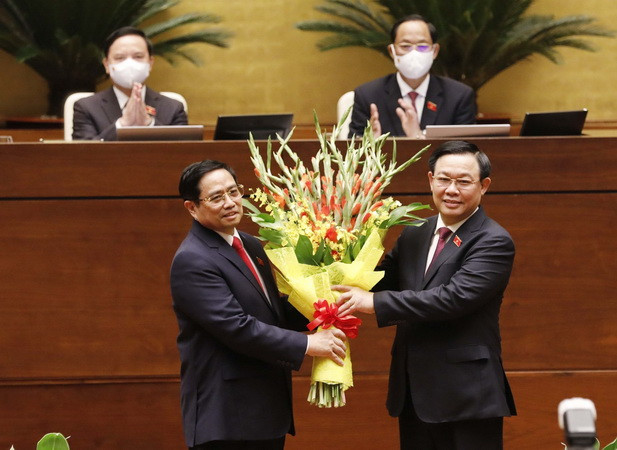 Chủ tịch Quốc hội Vương Đình Huệ tặng hoa chúc mừng Thủ tướng Phạm Minh Chính. (Ảnh: Trọng Đức/TTXVN) Thông cáo báo chí số 07, Kỳ họp thứ nhất, Quốc hội khóa XV ảnh 2
