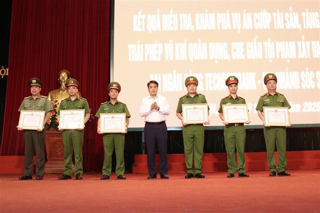 Chủ tịch UBND Hà Nội Nguyễn Đức Chung trao Bằng khen cho các cá nhân có thành tích xuất sắc. (Ảnh: Doãn Tấn/TTXVN) Khen thưởng 5 đơn vị phá chuyên án cướp tại Ngân hàng Techcombank ảnh 1