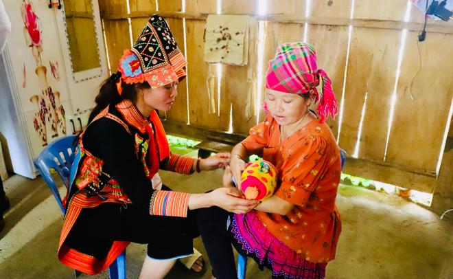 Cô đỡ thôn bản xã Mù Sang, huyện Phong Thổ, Lai Châu hướng dẫn người dân chăm sóc sức khoẻ trẻ sơ sinh. (Ảnh: Việt Đức/TTXVN) quyen con nguoi_02.jpg
