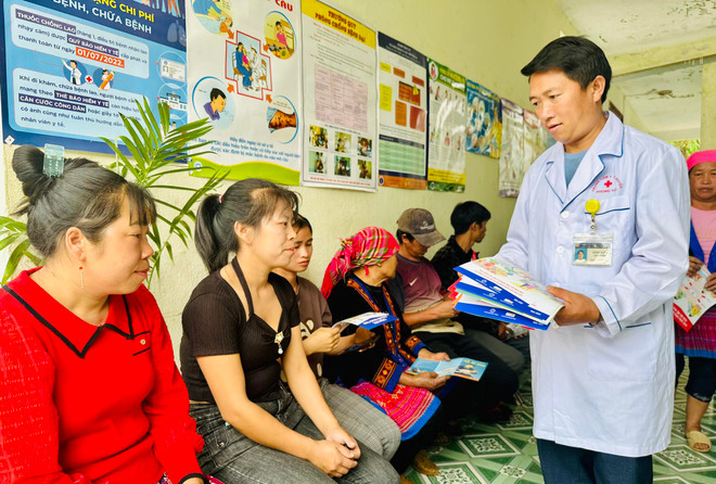 Bác sỹ tại trạm y tế xã Mù Sang, huyện Phong Thổ, Lai Châu phát tờ rơi tuyên truyền về sức khoẻ sinh sản cho người dân. (Ảnh: Việt Đức/TTXVN) quyen con nguoi_01.jpg