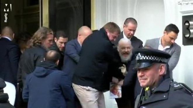 Nhà sáng lập WikiLeaks Julian Assange (giữa, phía sau) bị cảnh sát bắt giữ và áp giải khỏi Đại sứ quán Ecuador ở London ngày 11/4. (Nguồn: Rupity/TTXVN) Ecuador công bố chi phí bảo vệ ông Assange trong 7 năm ảnh 1