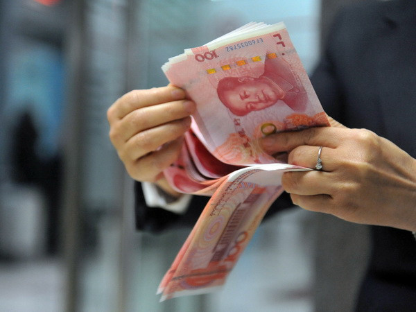 Nhân viên ngân hàng kiểm đồng nhân dân tệ tại một ngân hàng ở Hàng Châu, tỉnh Chiết Giang, miền Đông Trung Quốc. (Nguồn: AFP/TTXVN) Tỷ giá tham chiếu nhân dân tệ với USD lập kỷ lục trong năm 2017 ảnh 1