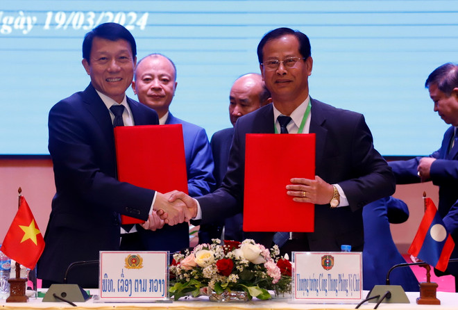 Thượng tướng Kongthong Phongvichit, Thứ trưởng Bộ Công an Lào, và Thượng tướng Lương Tam Quang, Thứ trưởng Bộ Công an Việt Nam trao Biên bản Hội nghị Hợp tác An ninh Lào-Việt Nam lần thứ 14. (Ảnh: Phạm Kiên/TTXVN) ttxvn_1903_viet lao (4).jpg