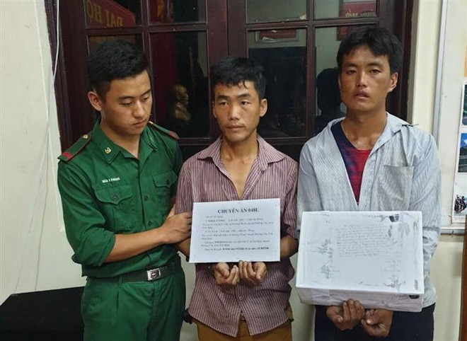 Hai đối tượng cùng tang vật tại cơ quan điều tra. (Ảnh: Xuân Tư/TTXVN) Bắt hai đối tượng vận chuyển 20.000 viên ma túy tổng hợp trong đêm ảnh 1