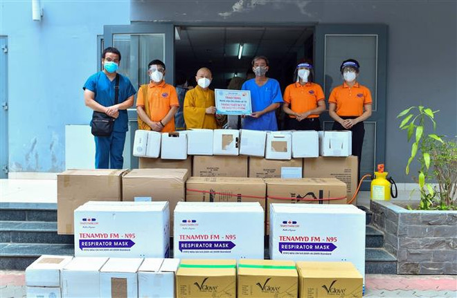 Thượng tọa Thích Nhật Từ (thứ 3 từ trái sang) thay mặt Quỹ Đạo Phật Ngày nay - Chùa Giác Ngộ trao tặng Bệnh viện Dã chiến 10 các trang thiết bị, vật tư y tế. (Ảnh: TTXVN phát) Tăng, ni, phật tử TP.HCM tích cực hỗ trợ phòng, chống dịch COVID-19 ảnh 1