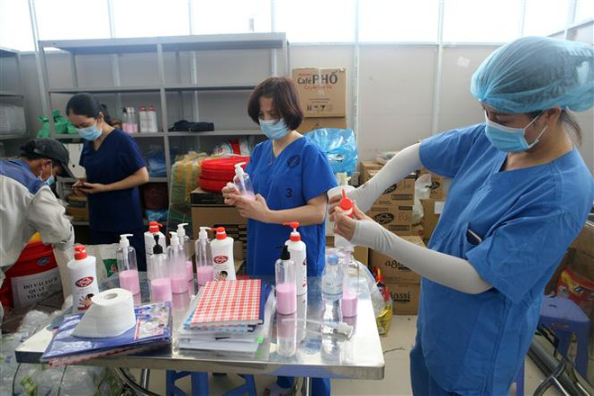 Nhân viên y tế đang chuẩn bị các dung dịch rửa tay sát khuẩn cho các phòng điều trị tại bệnh viện dã chiến. (Ảnh: Trần Lê Lâm/TTXVN) Đà Nẵng bổ sung các biện pháp cấp bách phòng, chống dịch COVID-19 ảnh 2