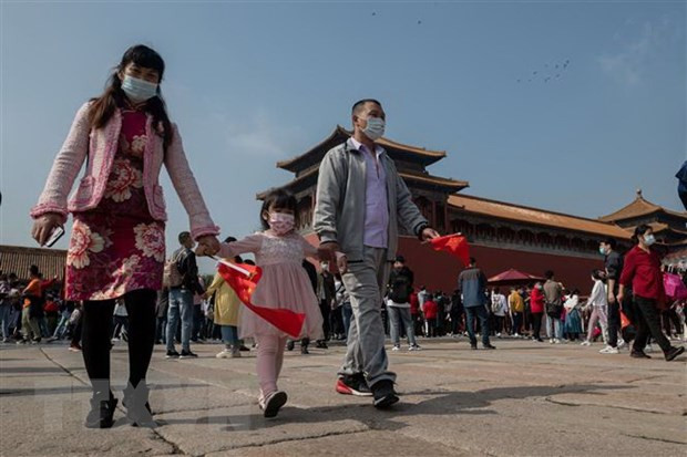 Người dân đeo khẩu trang phòng lây nhiễm COVID-19 khi tham quan Tử Cấm Thành tại Bắc Kinh, Trung Quốc. (Ảnh: AFP/TTXVN) Trung Quốc đối mặt với cuộc khủng hoảng về nhân khẩu học ảnh 1