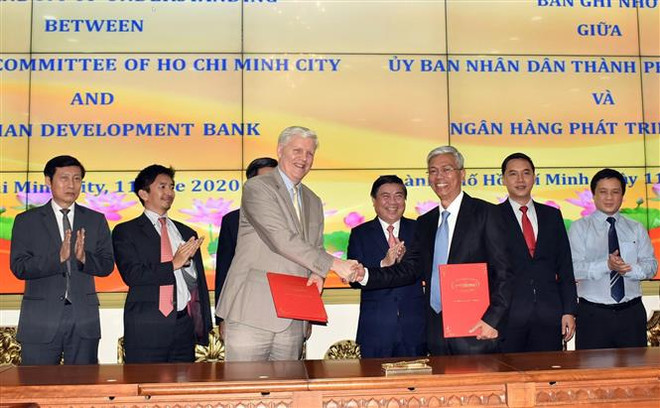 Ông Võ Văn Hoan, Phó Chủ tịch UBND Thành phố Hồ Chí Minh (phải) và ông Eric Sidgwick, Giám đốc ADB tại Việt Nam (trái) ký Bản ghi nhớ hợp tác giữa hai bên. (Ảnh: Xuân Khu/TTXVN) TP Hồ Chí Minh tăng cường hợp tác với Ngân hàng Phát triển châu Á ảnh 1