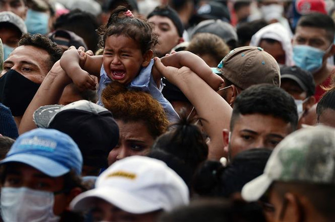 Người di cư Honduras phá hàng rào cảnh sát để vào Guatemala tìm đường tới Mỹ tại khu vực biên giới Corinto, Honduras. (Ảnh: AFP/TTXVN) Mexico kêu gọi người di cư không sử dụng trẻ em để tìm đường tới Mỹ ảnh 1