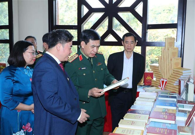 Bộ trưởng Bộ Quốc phòng Phan Văn Giang và các đại biểu xem gian trưng bày sách in và sách điện tử bên lề hội thảo. (Ảnh: Trọng Đức/TTXVN) Quân đội quán triệt tư tưởng của Tổng Bí thư về chống tham nhũng ảnh 3