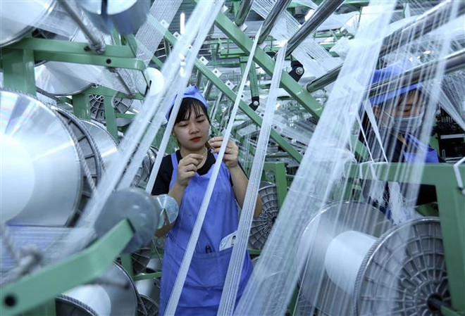 Dây chuyền sản xuất vải dệt kim tại Công ty TNHH Best Pacific Việt Nam, vốn đầu tư của Hồng Kong (Trung Quốc) tại khu công nghiệp VSIP (Hải Dương). (Ảnh: Danh Lam/TTXVN) ADB: Nhiều cơ sở để tin tưởng vào tiềm năng tăng trưởng của Việt Nam ảnh 1