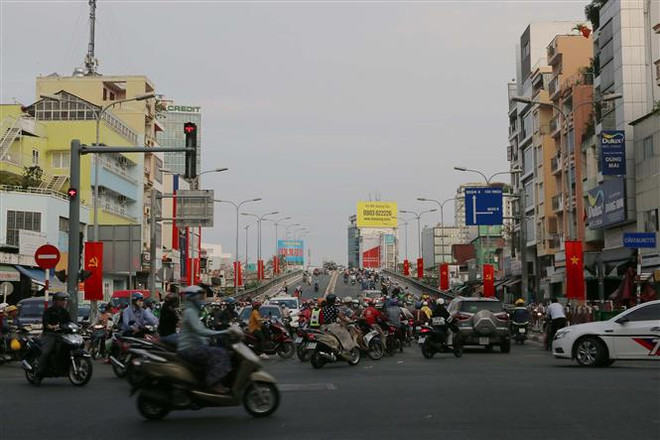Trang trí cờ hoa rực rỡ trên cầu Calmette, Quận 4. (Ảnh: Thanh Vũ/TTXVN) TP. Hồ Chí Minh 45 năm phát triển và khát vọng vươn lên tầm cao mới ảnh 2