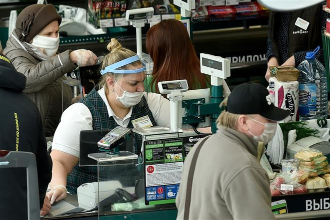 Nhân viên đeo khẩu trang phòng lây nhiễm COVID-19 tại Minsk, Belarus. (Ảnh: AFP/TTXVN) Số ca mắc COVID-19 tại Nga và Belarus tăng cao kỷ lục ảnh 2