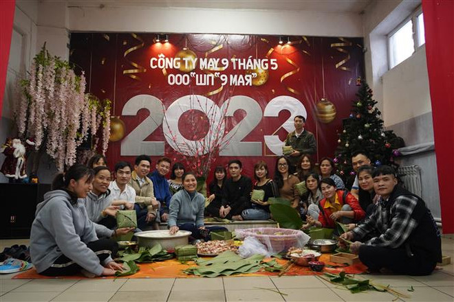 Công nhân Công ty may 9/5 quây quần gói bánh chưng trước thềm năm mới Quý Mão 2023. (Ảnh: Duy Trinh/TTXVN) Tết đầm ấm của những người công nhân Việt Nam tại Liên bang Nga ảnh 1