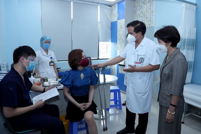 Thứ trưởng Kế hoạch&Đầu tư Nguyễn Thị Bích Ngọc và Phó giám đốc Bệnh viện Bạch Mai Đào Xuân Cơ động viên, hỏi thăm người khuyết tật tiêm vaccine sáng 29/7. (Nguồn: kinhtevadubao) Bộ Kế hoạch&Đầu tư chia sẻ quỹ vaccine, bảo vệ nhóm người khuyết tật ảnh 1