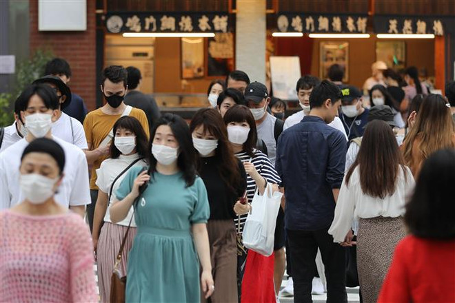 Người dân đeo khẩu trang phòng lây nhiễm COVID-19 tại Tokyo, Nhật Bản. (Ảnh: THX/TTXVN) COVID-19 phá vỡ thời kỳ ổn định chính trị ở Nhật Bản ảnh 1