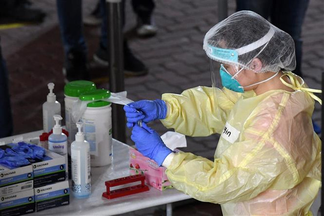 Nhân viên y tế xét nghiệm COVID-19. Ảnh minh họa. (Ảnh: AFP/TTXVN) Nhật Bản phát triển phương pháp xét nghiệm nhanh COVID-19 qua nước bọt ảnh 1