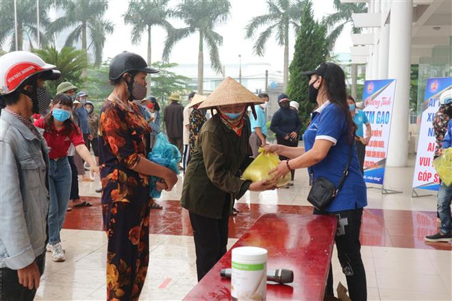Phát gạo cho người dân gặp khó khăn do dịch COVID-19. (Ảnh: Hoàng Ngà/TTXVN) Thủ tướng: Hỗ trợ người dân gặp khó khăn phải kịp thời, chính xác ảnh 1