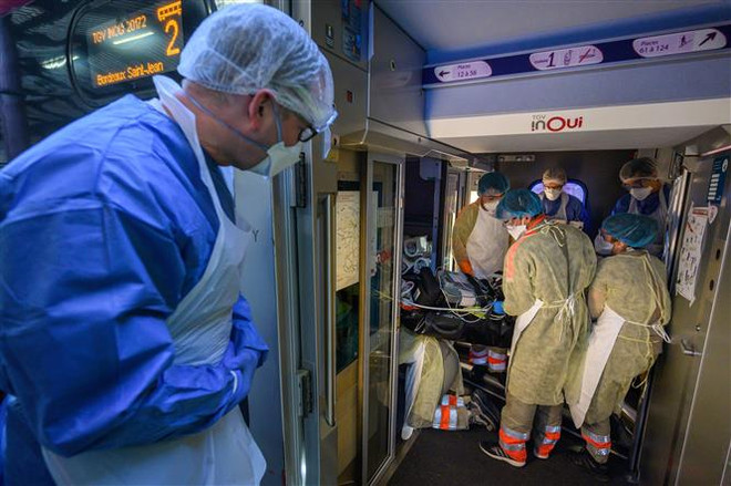 Nhân viên y tế chuyển bệnh nhân nhiễm COVID-19 tới bệnh viện ở Strasbourg, Pháp. (Ảnh: AFP/TTXVN) Số ca phải điều trị tích cực ở Pháp, Italy tiếp tục xu hướng giảm dần ảnh 2