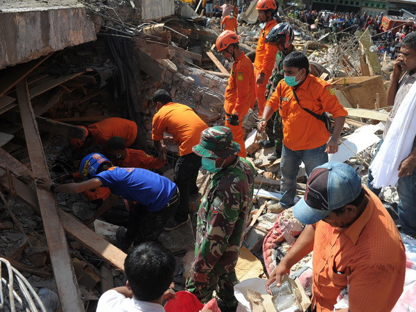 Lực lượng cứu hộ Indonesia tìm kiếm các nạn nhân còn mắc kẹt trong đống đổ nát sau trận động đất tại tỉnh Aceh ngày 7/12. (Ảnh: AFP/TTXVN) Lãnh đạo Việt Nam gửi điện thăm hỏi về vụ động đất ở Indonesia ảnh 1