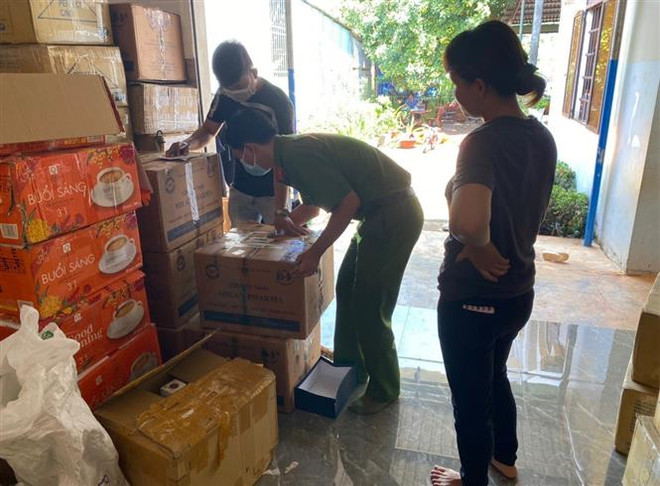 Lực lượng chức năng kiểm tra, phát hiện số lớn hàng hóa không rõ nguồn gốc. (Ảnh: TTXVN phát) Thu hơn 10.000 sản phẩm mỹ phẩm, thực phẩm chức năng không rõ xuất xứ ảnh 1