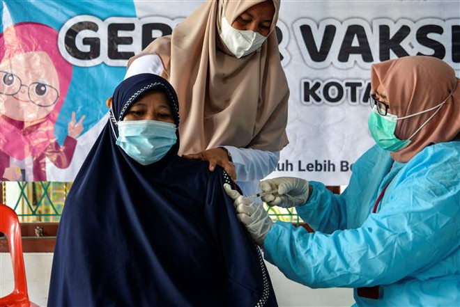 Một điểm tiêm chủng vaccine ngừa COVID-19 tại Banda Aceh, Indonesia. (Ảnh: AFP/TTXVN) Dịch COVID-19: Indonesia quyết định áp đặt lệnh phong tỏa khẩn cấp ảnh 1