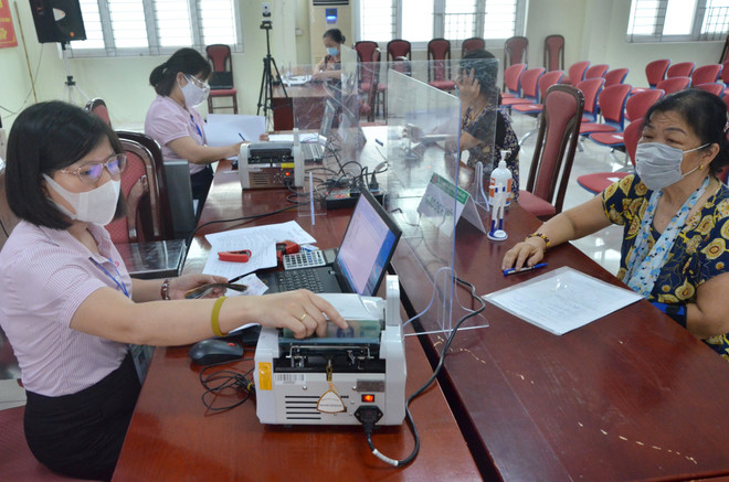 Giao dịch tại Ngân hàng Chính sách xã hội. (Ảnh: Vietnam+) Gắn tín dụng chính sách xã hội với chuyển giao KHCN, đào tạo nghề ảnh 1