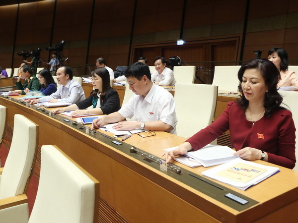 Đại biểu Quốc hội bấm nút biểu quyết thông qua Luật Đấu giá tài sản. (Ảnh: Phạm Kiên/TTXVN) Quốc hội thông qua Luật Đấu giá tài sản với hơn 84% số phiếu tán thành ảnh 1