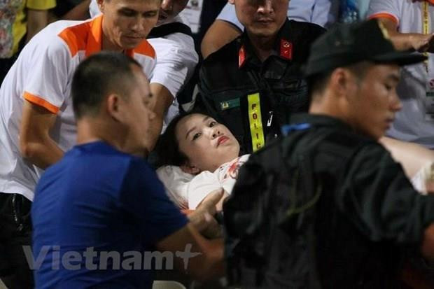Nữ cổ động viên phải đưa đi cấp cứu gấp. (Ảnh: Vietnam+) Phê chuẩn quyết định khởi tố, tạm giam bị can bắn pháo ở sân Hàng Đẫy ảnh 1