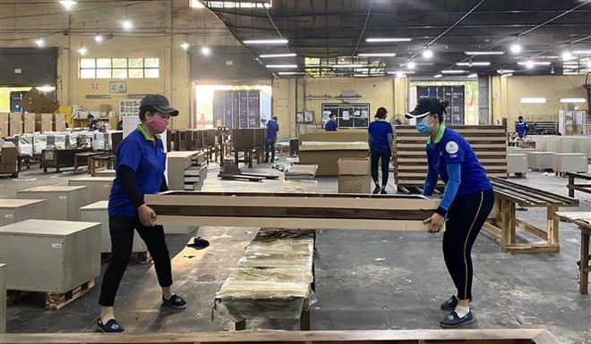 Công nhân Công ty Cổ phần Chế biến gỗ Thuận An kiểm tra các chi tiết khung giường gỗ. (Ảnh: Hồng Nhung/TTXVN) Xuất khẩu tăng cao nhưng doanh nghiệp không thể chủ quan bởi dịch ảnh 2