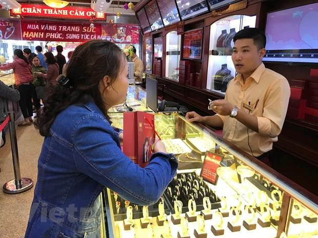 Khách hàng giao dịch vàng. (Ảnh: Đức Duy/Vietnam+) Thị trường vàng trong nước ghi nhận tuần tăng giá ảnh 1