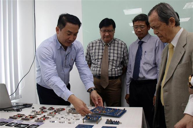 Các đai biểu nghe giới thiệu về chip của Đại học Bách khoa Thành phố Hồ Chí Minh tại Phòng Thiết kế vi mạch. (Ảnh: Tiến Lực/TTXVN) Khánh thành Trung tâm Thiết kế vi mạch tại Khu Công nghệ cao TP.HCM ảnh 2