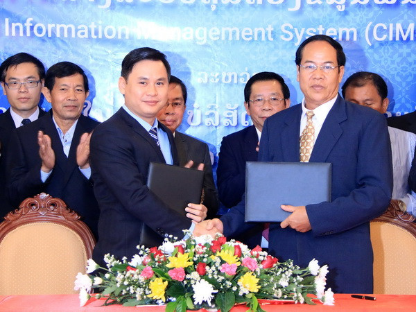 Ông Cao Anh Sơn (trái), Tổng Giám đốc Công ty Star Telecom và ông Thongchan Sivilay, Cục trưởng Cục quản lý hộ khẩu, Bộ Nội vụ Lào đang trao cho nhau Hợp đồng. (Ảnh: Phạm Kiên/Vietnam+) Viễn thông Lào-Việt hỗ trợ Lào xây dựng hệ thống quản lý dân số ảnh 2