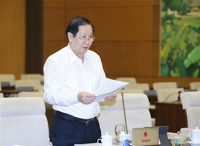 Bộ trưởng Bộ Nội vụ Lê Vĩnh Tân trình bày Tờ trình. (Ảnh: Doãn Tấn/TTXVN) Tán thành việc thành lập Văn phòng Đoàn đại biểu Quốc hội và HĐND ảnh 5