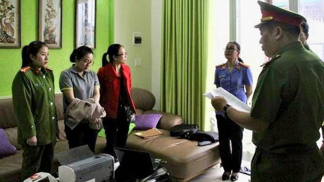 Cơ quan công an đọc lệnh bắt Nguyễn Thị Huyền Trang-áo xám. (Nguồn: vov.vn) Lâm Đồng: Bắt tạm giam nữ nhân viên bưu điện tham ô hơn 3 tỷ đồng ảnh 1