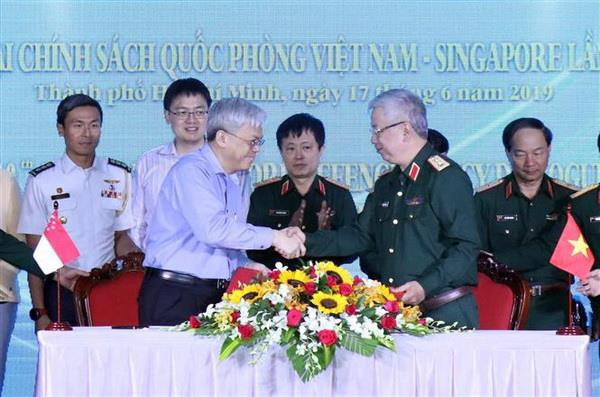 Thượng tướng Nguyễn Chí Vịnh và ông Chan Yeng Kit ký Kế hoạch hợp tác song phương. (Ảnh: Xuân Khu/TTXVN) Tăng cường hợp tác quốc phòng giữa Việt Nam và Singapore ảnh 1