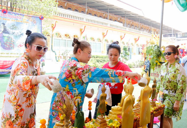 Người dân thực hiện nghi thức tắm Phật, một trong những hoạt động tôn giáo không thể thiếu trong Bun Pi May. (Ảnh: Phạm Kiên/TTXVN) Người dân đất nước Triệu Voi tưng bừng đón Tết cổ truyền dân tộc ảnh 2