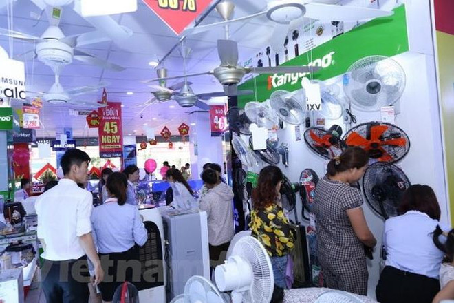 Người dân đi mua sắm các thiết bị chống nắng nóng. (Ảnh: Thanh Tâm/Vietnam+) Sức mua các mặt hàng giải nhiệt tăng gấp hai, ba lần ảnh 1