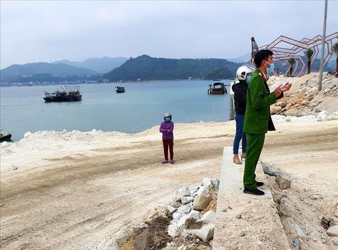 Lực lượng chức năng tại hiện trường khu vực nơi doanh nghiệp đổ trộm đất đá xuống vịnh Bái Tử Long. (Ảnh: TTXVN phát) Xử phạt 100 triệu đồng công ty đổ trộm đất ra vịnh Bái Tử Long ảnh 1