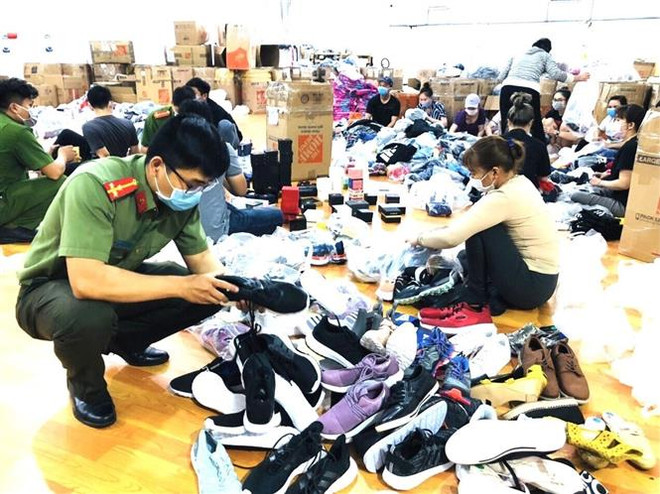 Các sản phẩm không hóa đơn chứng từ bị lực lượng chức năng kiểm tra. (Ảnh: TTXVN phát) Đồng Nai: Phát hiện kho 'hàng hiệu' không có hóa đơn chứng từ ảnh 1