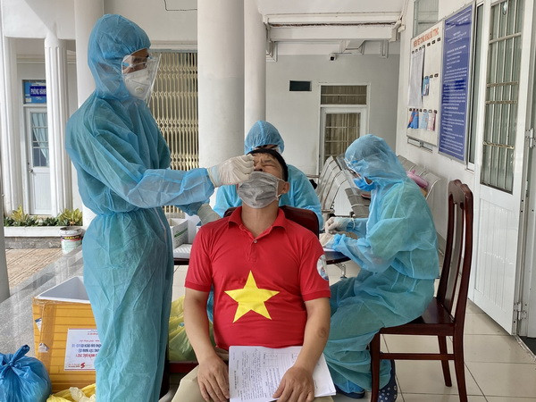 Test nhanh kháng nguyên SARS-CoV-2 trước khi tiêm vaccine. (Ảnh: Thanh Sang/TTXVN) Ngày 27/8: Việt Nam ghi nhận 12.920 ca nhiễm, 356 ca tử vong ảnh 2