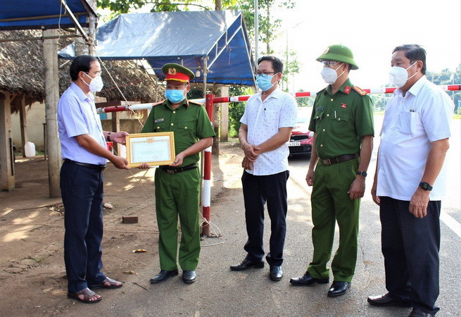 Phó Bí thư Thường trực Huyện ủy Châu Đức, tỉnh Bà Rịa-Vũng Tàu Nguyễn Tấn Bản trao bằng khen cho Thiếu tá Trương Huy Dũng. (Ảnh: TTXVN phát) Khen thưởng cán bộ chốt kiểm soát dịch kịp thời đưa sản phụ đi viện ảnh 1