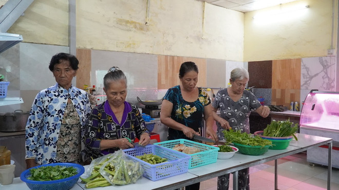 Những tình nguyện viên của Hội Chữ thập đỏ Vòng Tay nhân ái đang chuẩn bị các suất ăn trưa cho người nghèo. (Ảnh: Văn Sỹ/TTXVN) Kiên Giang: Ấm lòng người nghèo từ quán cơm 0 đồng và 5.000 đồng ảnh 1