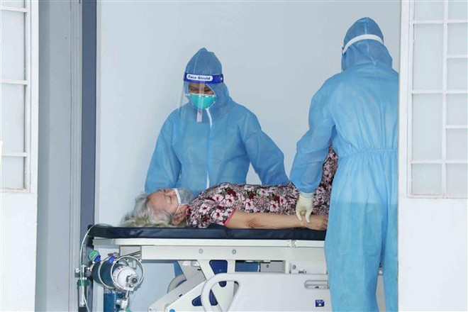 Các bác sỹ Bệnh viện dã chiến thu dung điều trị COVID-19 số 4 (xã Vĩnh Lộc B, huyện Bình Chánh) chăm sóc bệnh nhân COVID-19. (Ảnh: Xuân Khu/TTXVN) Bộ Y tế yêu cầu bảo đảm công tác cấp cứu, điều trị người bệnh COVID-19 ảnh 1